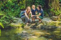 Happy family feeding colorful Catfish in tropical pond