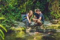 Happy family feeding colorful Catfish in tropical pond