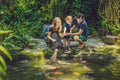 Happy family feeding colorful Catfish in tropical pond