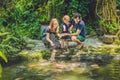 Happy family feeding colorful Catfish in tropical pond