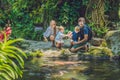 Happy family feeding colorful Catfish in tropical pond