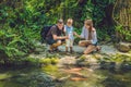 Happy family feeding colorful Catfish in tropical pond