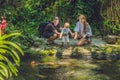 Happy family feeding colorful Catfish in tropical pond