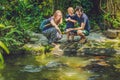 Happy family feeding colorful Catfish in tropical pond