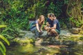 Happy family feeding colorful Catfish in tropical pond