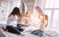 The happy family fighting with pillows on the bed. Royalty Free Stock Photo