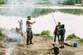 A happy family is fishing on the bank of a river or lake. Spending time together, family time, family vacation Royalty Free Stock Photo