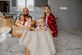 Happy family of five posing in empty house, sitting on the floor among boxes. Royalty Free Stock Photo