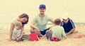 Happy family of five sitting at sandy beach Royalty Free Stock Photo