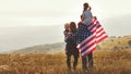 Happy family with flag of america USA at sunset outdoors