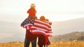 Happy family with flag of america USA at sunset outdoors Royalty Free Stock Photo