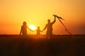 Happy family flying kite in the field at sunset Royalty Free Stock Photo