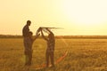 Happy family flying kite in the field at sunset Royalty Free Stock Photo