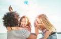 Happy family flying with kite and having fun on the beach - Multi ethnic couple playing with cheerful daughter on weekend vacation Royalty Free Stock Photo