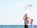 Happy family flying kite near sea Royalty Free Stock Photo