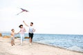 Happy family flying kite near sea Royalty Free Stock Photo