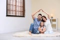 Happy family forming house roof with hands at home. Insurance concept Royalty Free Stock Photo