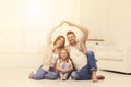 Happy family forming house roof with their hands at home. Insurance concept Royalty Free Stock Photo