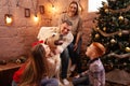 A happy family of four and a dog celebrate the New Year. Dad, mom, son and daughter love the dog and have fun against the Royalty Free Stock Photo