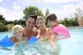 Happy family of four enjoying swimming pool Royalty Free Stock Photo