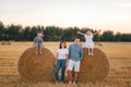 Happy family of four having fun and playing in a wheat field in summer at sunset time Royalty Free Stock Photo