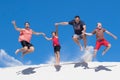 Happy family of four jump from high white sand dune having fun Royalty Free Stock Photo