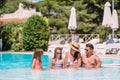 Happy family of four in outdoors swimming pool Royalty Free Stock Photo