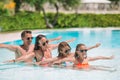 Happy family of four in outdoors swimming pool Royalty Free Stock Photo