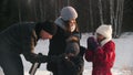 Happy family of four people drinking hot drinks from the termos in winter time