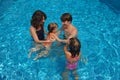 Happy family of four in the pool