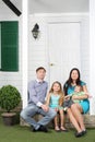 Happy family of four sit on porch of new their cottage. Royalty Free Stock Photo