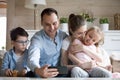 Smiling father making selfie of happy family of four