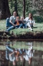 Happy family of four sitting on the grass on the lake Royalty Free Stock Photo