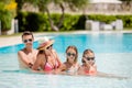 Happy family of four in swimming pool Royalty Free Stock Photo