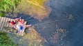 Happy family and friends fishing together outdoors near lake in summer, aerial top view