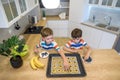 Happy family funny kids are preparing the dough, bake cookies in the kitchen. Put berry and blueberry in all biscuits Royalty Free Stock Photo