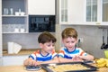 Happy family funny kids are preparing the dough, bake cookies in the kitchen. Put berry and blueberry in all biscuits Royalty Free Stock Photo