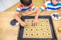 Happy family funny kids are preparing the dough, bake cookies in the kitchen. Put berry and blueberry in all biscuits Royalty Free Stock Photo