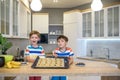 Happy family funny kids are preparing the dough, bake cookies in the kitchen. Put berry and blueberry in all biscuits Royalty Free Stock Photo