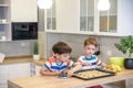 Happy family funny kids are preparing the dough, bake cookies in the kitchen. Put berry and blueberry in all biscuits Royalty Free Stock Photo