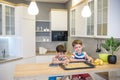 Happy family funny kids are preparing the dough, bake cookies in the kitchen. Put berry and blueberry in all biscuits Royalty Free Stock Photo