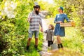 Happy family in garden. Wife and husband with son planting in the vegetable garden. A pair with child of farms working