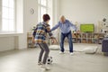 Elderly grandfather playing football with grandson in home living room