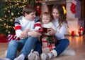 Happy family with gifts sitting at Christmas tree Royalty Free Stock Photo