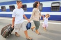 Happy family with girl going on railway station