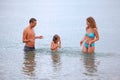 Happy family with girl splashes water hands