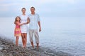 Happy family with girl standing on beach Royalty Free Stock Photo