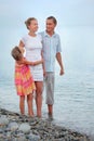 Happy family with girl standing on beach, evening Royalty Free Stock Photo