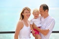 Happy family with girl on veranda near seacoast