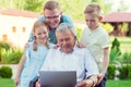 Happy family with grandfather during internet talking on laptop Royalty Free Stock Photo